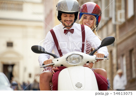 Hipster  couple riding a scooter on a sunny day in 54613075