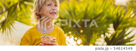 Boy drink healthy smoothies against the backdrop of palm trees. Watermelon smoothies. Healthy 54614549