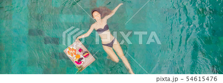 BANNER, LONG FORMAT Breakfast tray in swimming pool, floating breakfast in luxury hotel. Girl 54615476