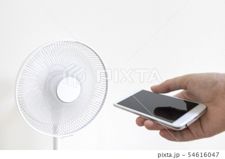スマートフォンで扇風機を操作するイメージの写真素材