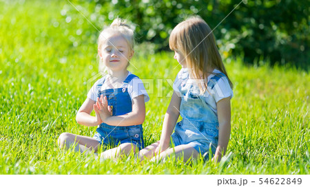 A girl teaches her friend yoga poses. A girl teaches her friend yoga poses. 54622849