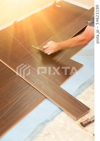 Man Installing New Laminate Wood Flooring Man Installing New Laminate Wood Flooring 54623190