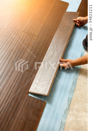 Man Installing New Laminate Wood Flooring Man Installing New Laminate Wood Flooring 54623211