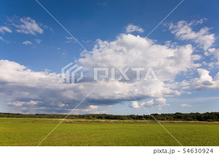 Cloudy sky and sun over cultivated meadows 54630924