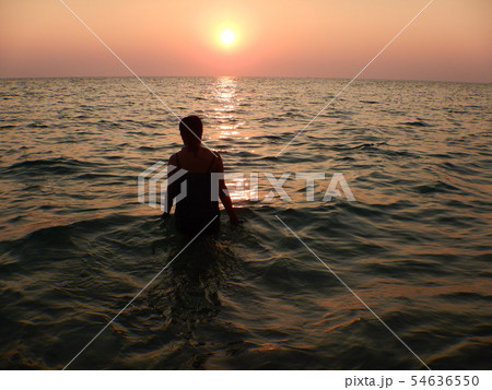 海に沈む夕日と後ろ姿 海に沈む夕日と後ろ姿 54636550