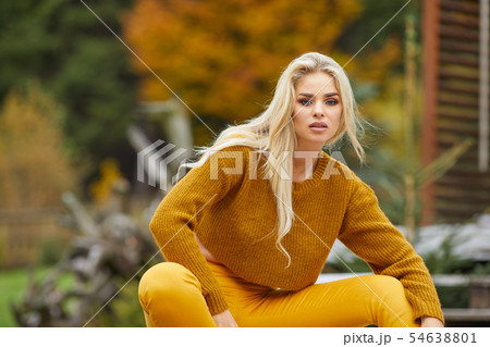 Autumn woman relaxing on a wooden terrace in the Autumn woman relaxing on a wooden terrace in the 54638801