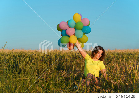 Young girl with big bunch of colorful balloons Young girl with big bunch of colorful balloons 54641429