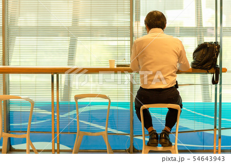 Businessmen sitting in service counter in airport lounge waiting for departure. Businessmen sitting in service counter in airport lounge waiting for departure. 54643943