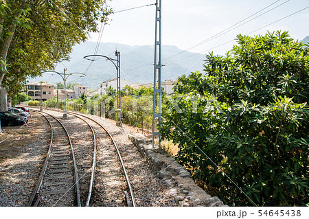 マヨルカの郊外　路面電車の線路とレンガ造りの家並みと遠くに霞んで見える山々 54645438