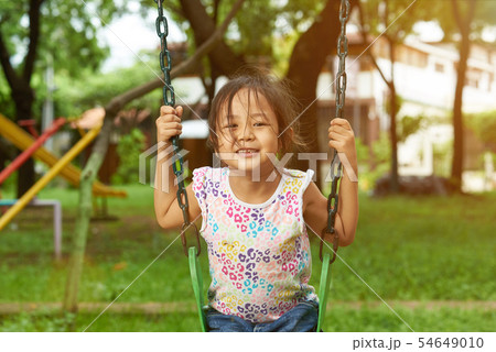 Asian girl on a swing smiling Asian girl on a swing smiling 54649010
