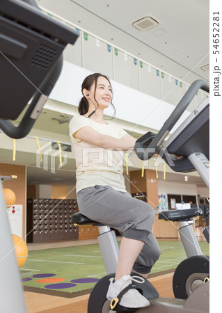 フィットネスジム　スポーツジム　バイク　自転車　女性　イヤホン　音楽 54652281