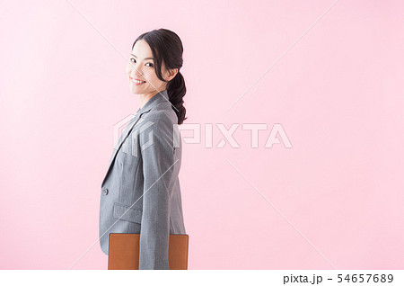 スーツの20代女性（ピンク色背景） 54657689
