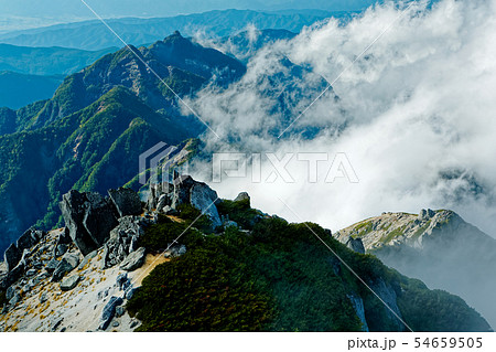 甲斐駒ヶ岳山頂から雲湧く鋸岳稜線 54659505