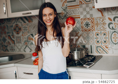 Sports girl in a kitchen with vegetables Sports girl in a kitchen with vegetables 54662725