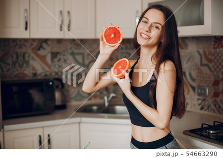 Sports girl in a kitchen with fruits Sports girl in a kitchen with fruits 54663290