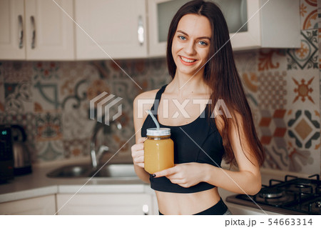 Sports girl in a kitchen with fruits 54663314