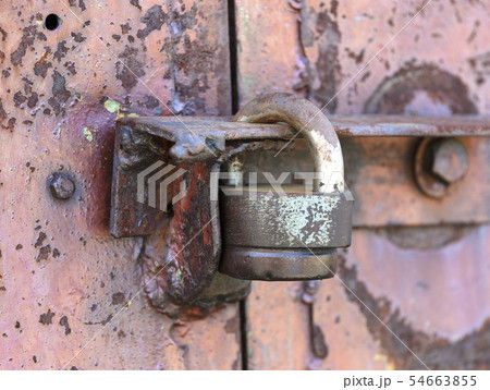 The padlock on the door. Rusty gate The padlock on the door. Rusty gate 54663855