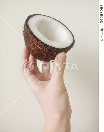 Hand holding sliced coconut 54667067