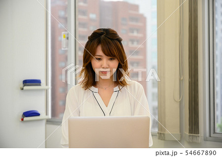PCに向かって楽しげに仕事をこなす若い女性 54667890