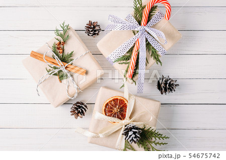Gift box with pine cones and cinnamon sticks 54675742