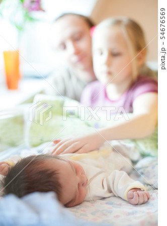 father and daughter look at the newborn.  54676569