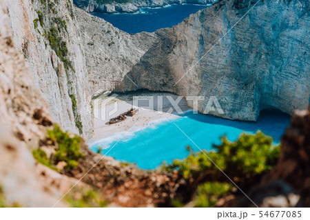 Famous shipwreck on Navagio beach with turquoise blue sea water surrounded by huge white cliffs Famous shipwreck on Navagio beach with turquoise blue sea water surrounded by huge white cliffs 54677085
