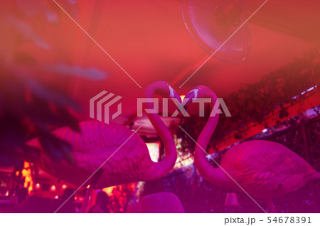 A pink flamingo ceramic facing each other to form a heart shape 54678391