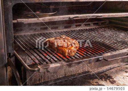 food, craft and delicious concept - cooking steak on a grill 54679503