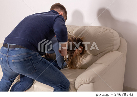 people, domestic violence and abuse concept - young man threatens his wife with his fist on white people, domestic violence and abuse concept - young man threatens his wife with his fist on white 54679542