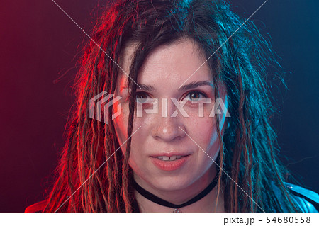 Style, youth, people concept - young cheerful woman with dreadlock looks like rocker over dark Style, youth, people concept - young cheerful woman with dreadlock looks like rocker over dark 54680558