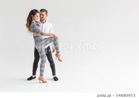 Social dance, bachata, kizomba, zouk, tango concept - Man hugs woman while dancing over white Social dance, bachata, kizomba, zouk, tango concept - Man hugs woman while dancing over white 54680953