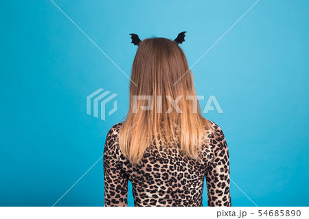 The evil woman with a waist bat on the head. Fancy dress for Halloween on blue background, back view 54685890