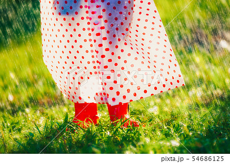 girl with raincoat and boots is walking under rain girl with raincoat and boots is walking under rain 54686125