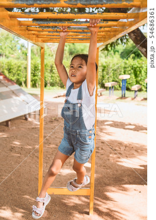 Cute asian child girl hang the bar by her hand Cute asian child girl hang the bar by her hand 54686361