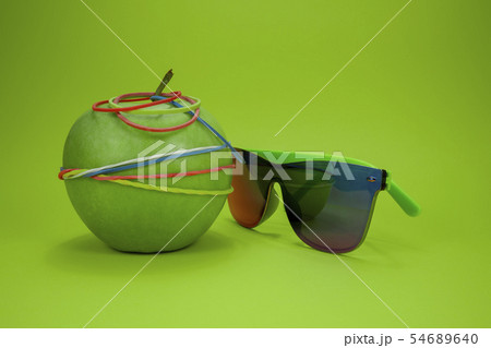 Apple tied in rubber bands and fashion sunglasses 54689640
