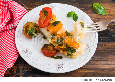 Baked cod fillet with cherry tomato and basil Baked cod fillet with cherry tomato and basil 54689896