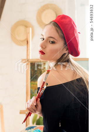 Attractive artist girl with long hair in red beret Attractive artist girl with long hair in red beret 54693632