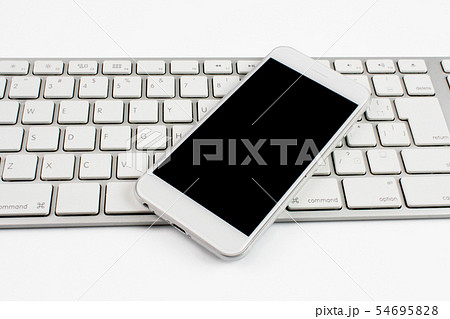 スマホ スマートフォン とpcキーボード 白バック シンプルイメージの写真素材