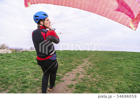 Skydiver pulls parachute behined him after landing Skydiver pulls parachute behined him after landing 54696059
