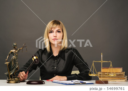 A young fair woman judge works in her office. A young fair woman judge works in her office. 54699761