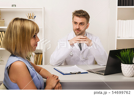Young woman on a consultation with a male surgeon Young woman on a consultation with a male surgeon 54699762
