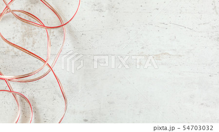 Top down view - two wires red and transparent copper speaker cable on white stone board desk, wide Top down view - two wires red and transparent copper speaker cable on white stone board desk, wide 54703032
