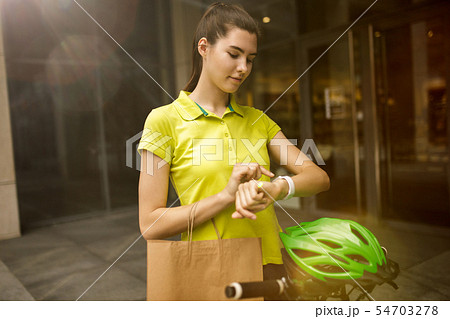 Young woman as a courier delivering package using gadgets Young woman as a courier delivering package using gadgets 54703278