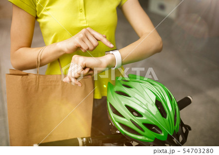 Young woman as a courier delivering package using gadgets Young woman as a courier delivering package using gadgets 54703280