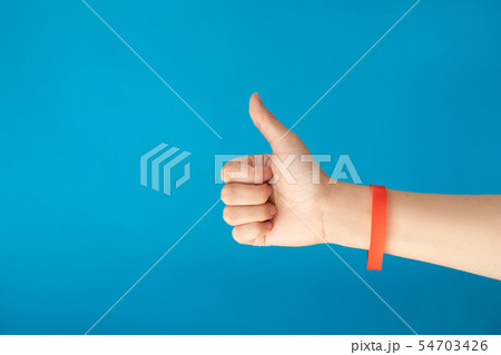 Female hand with empty red bracelet on blue backgr 54703426