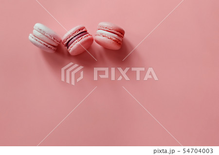 Three macaroons on a coral background. Three macaroons on a coral background. 54704003