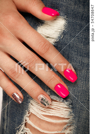 Bright neon manicure on female hands on the background of jeans. Nail design. Beauty hands. 54708647