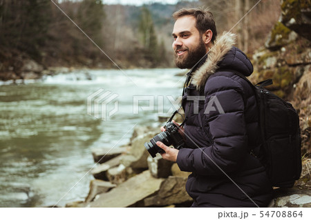 Man traveler photographer with camera photographing the river 54708864