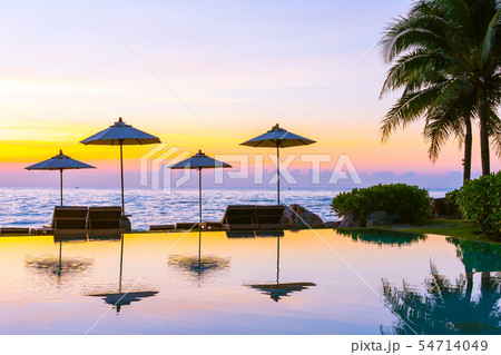 Umbrella and chair around swimming pool in resort hotel for leisure travel and vacation 54714049
