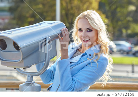 Cheerful young tourist using telescope tower Cheerful young tourist using telescope tower 54722159